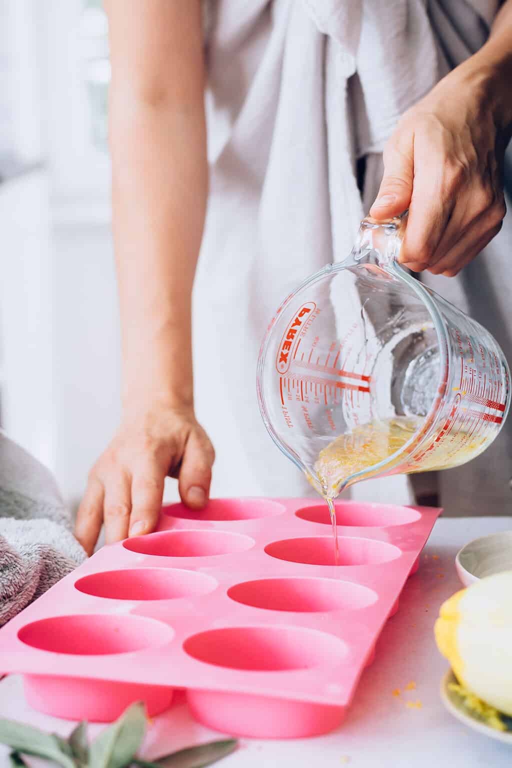 Pouring melted lotion bar ingredients into molds
